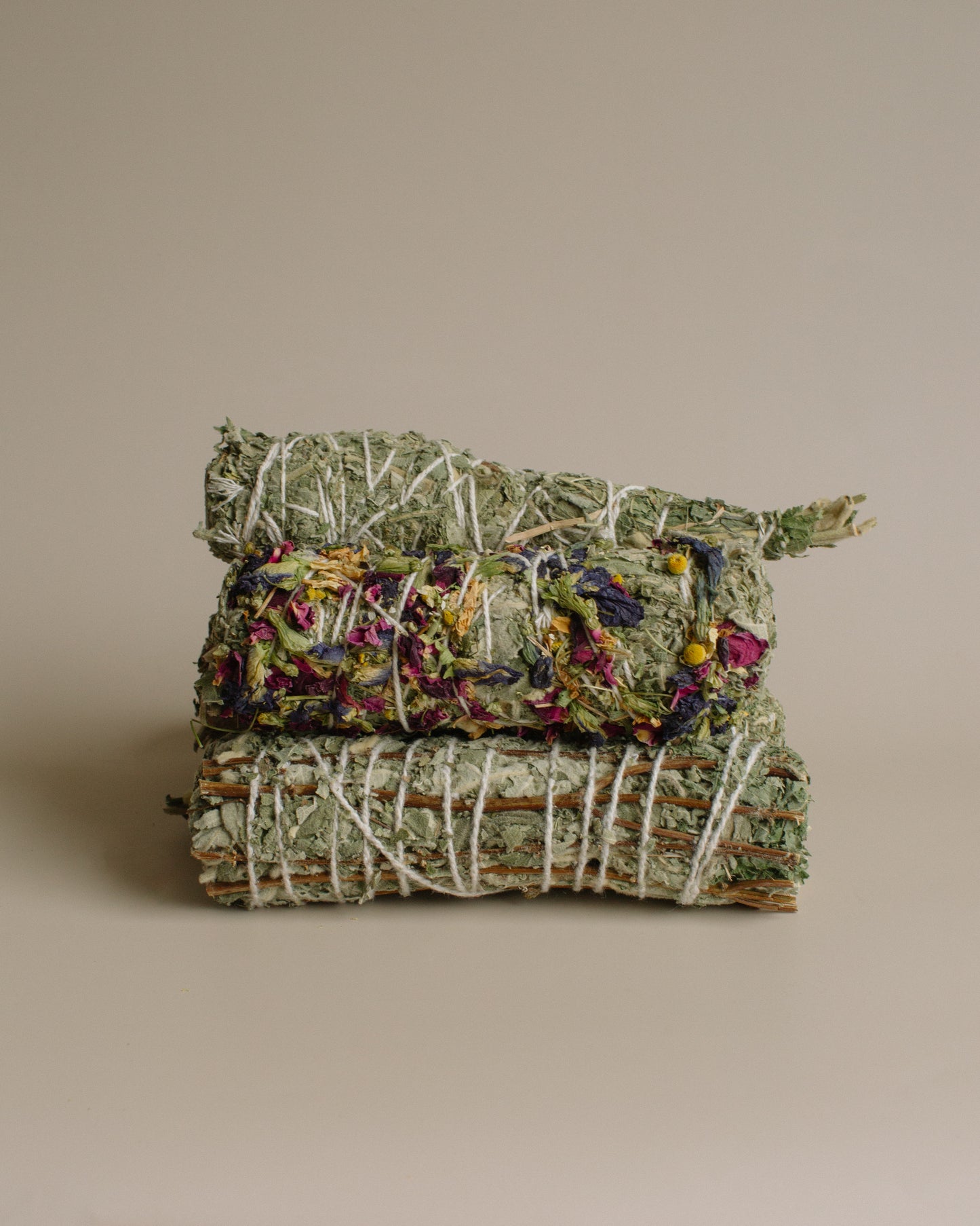 Stack of Sage and variations of smoke bundles stacked on a beige background