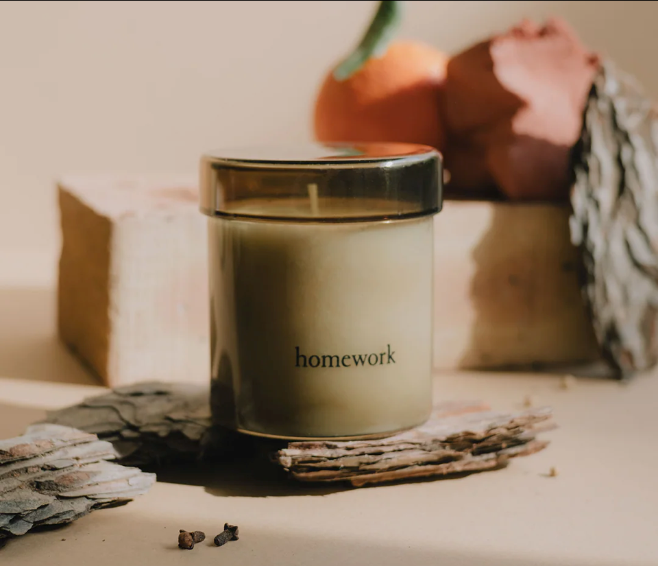 Candle labeled 'homework' on a surface with decorative elements