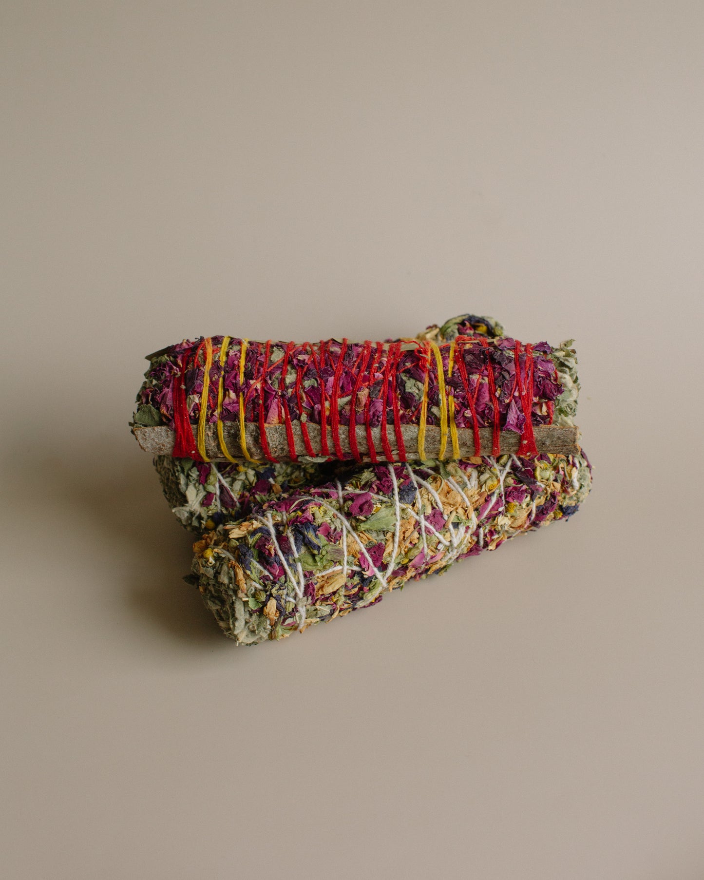 Stack of colorful smoke bundles a beige background