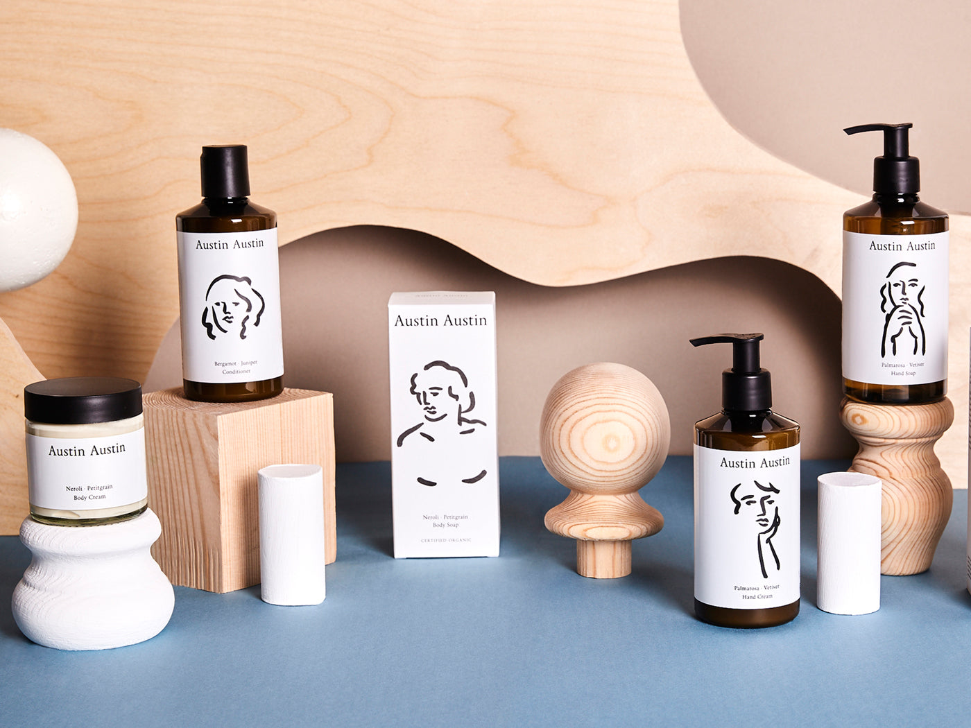 Pots and bottles of products with sculptural wooden and blue background