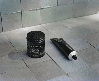 A jar and a tube on a tiled floor