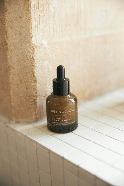 Brown bottle with dropper labeled 'sans' on a tiled surface.