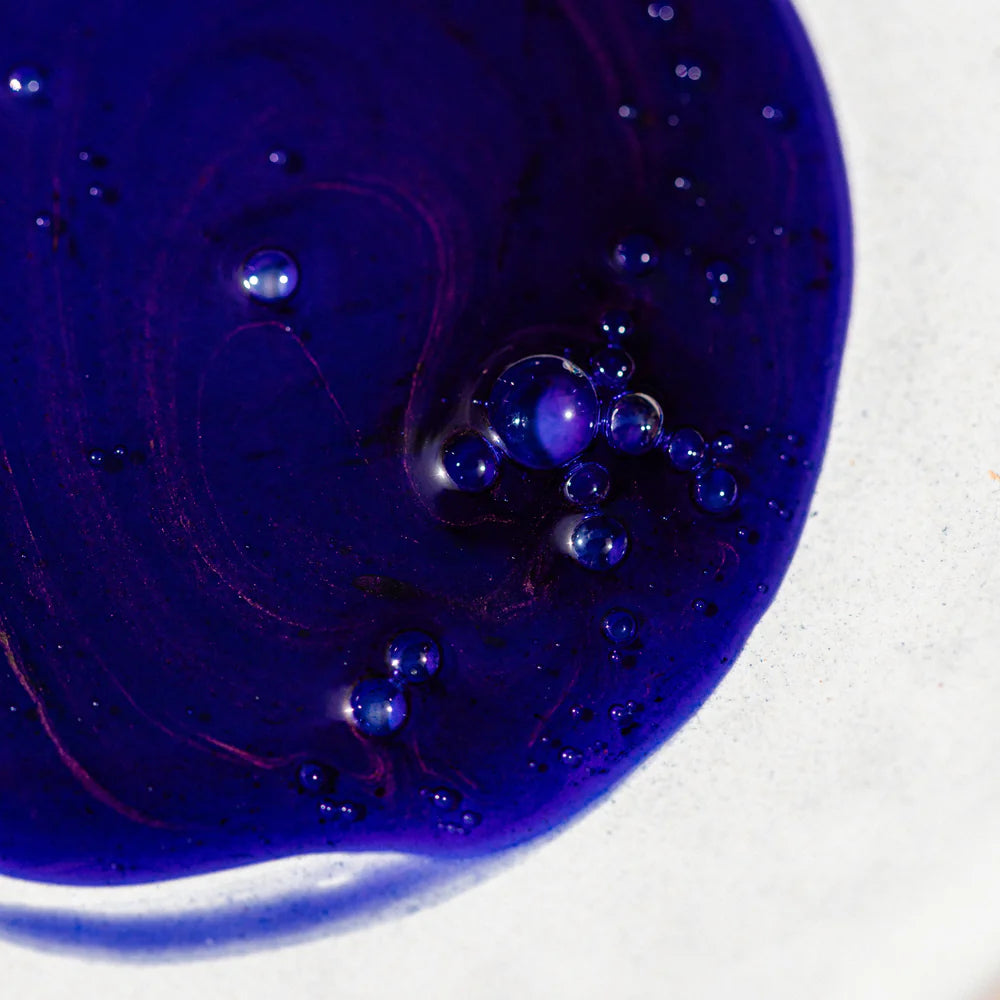 Close-up of blue liquid with bubbles on a white background