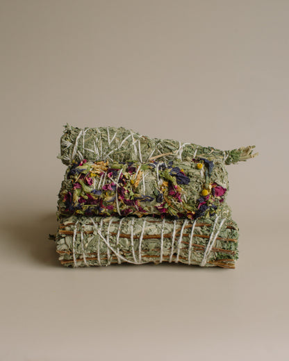 Stack of Sage and variations of smoke bundles stacked on a beige background