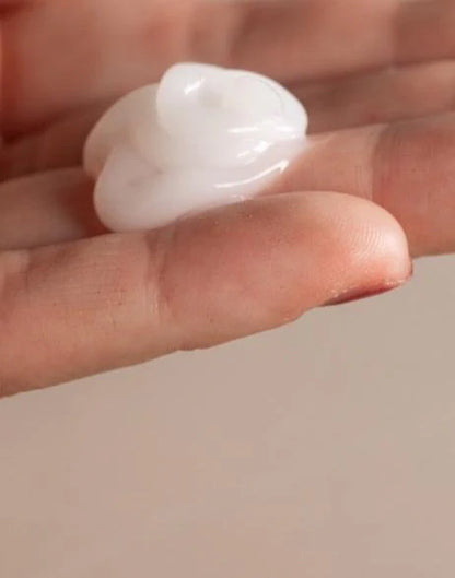 Small white cram product held between fingers against a neutral background