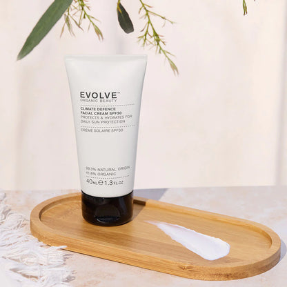 White tube of evolve face cream standing on a wooden tray against a white background