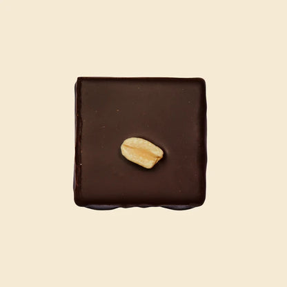 Square chocolate bar with a peanut on a beige background