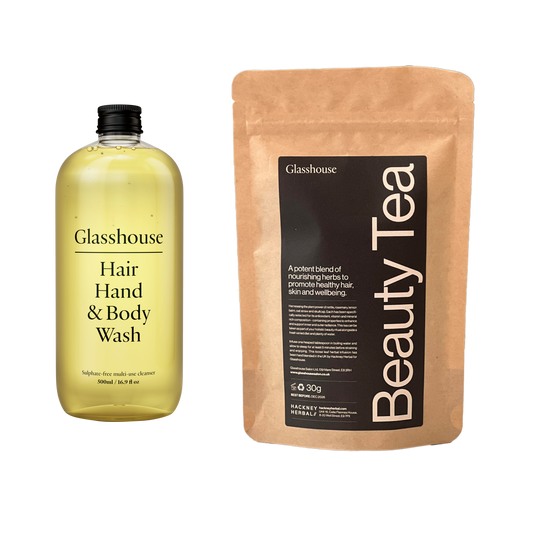 Glasshouse Hair Hand & Body Wash bottle and Beauty Tea packaging on a white background