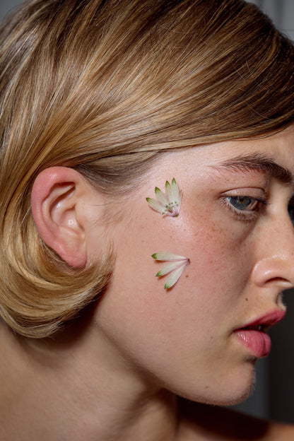 Glasshouse Salon Toner and Liquid Gloss on model with nautural makeup by RMS beauty and plants on her face for decoration