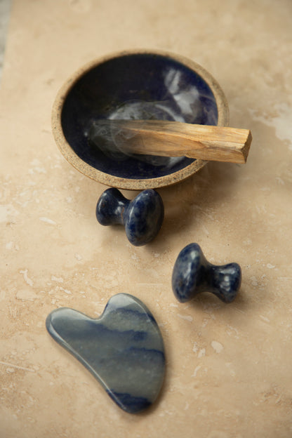 Set of stone gua sha and crystal mushrooms Used in holistic facials at Glasshouse salon in east London with burning palo santo