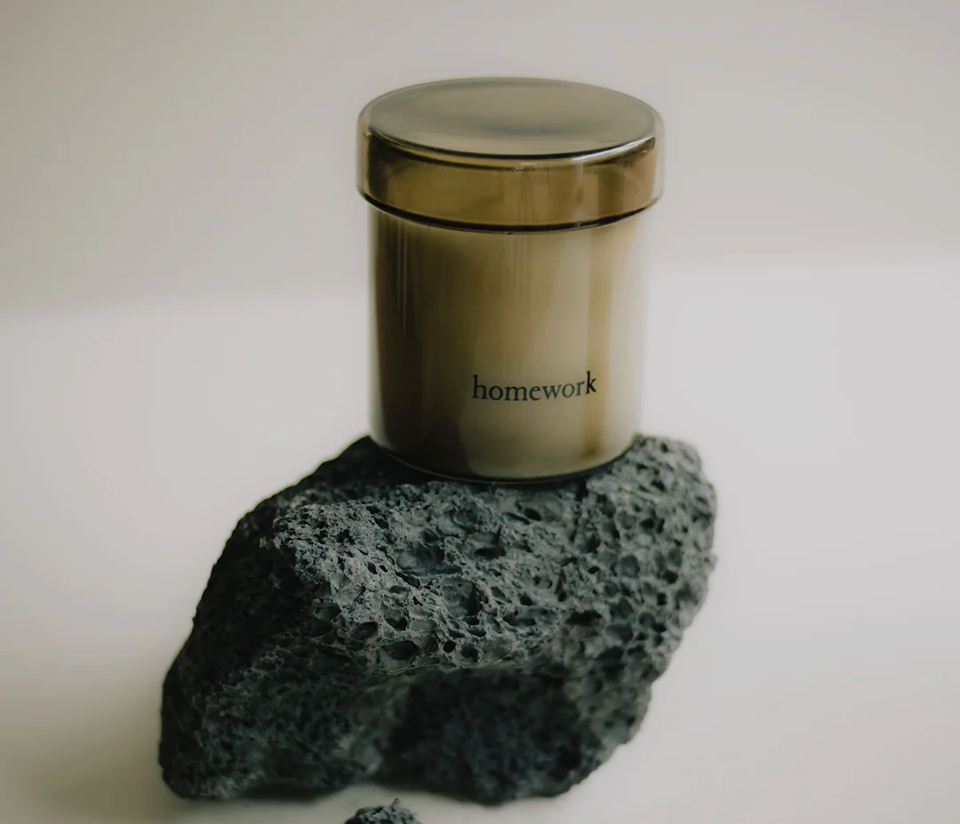 Jar candle labeled 'homework' on a rock textured grey surface