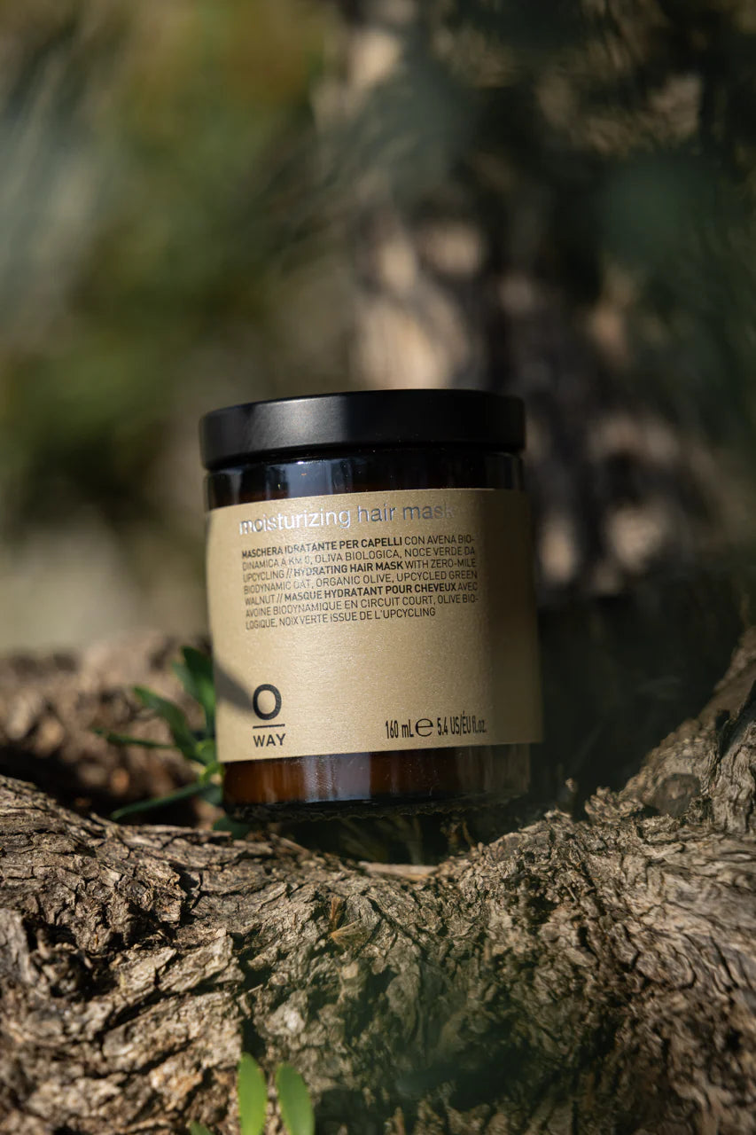 Jar of hair mask on a tree branch with a blurred natural background
