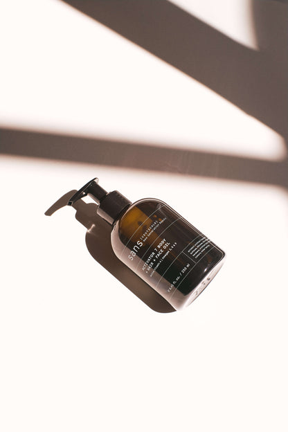 Skincare bottle with pump on a white background with shadows from the sun
