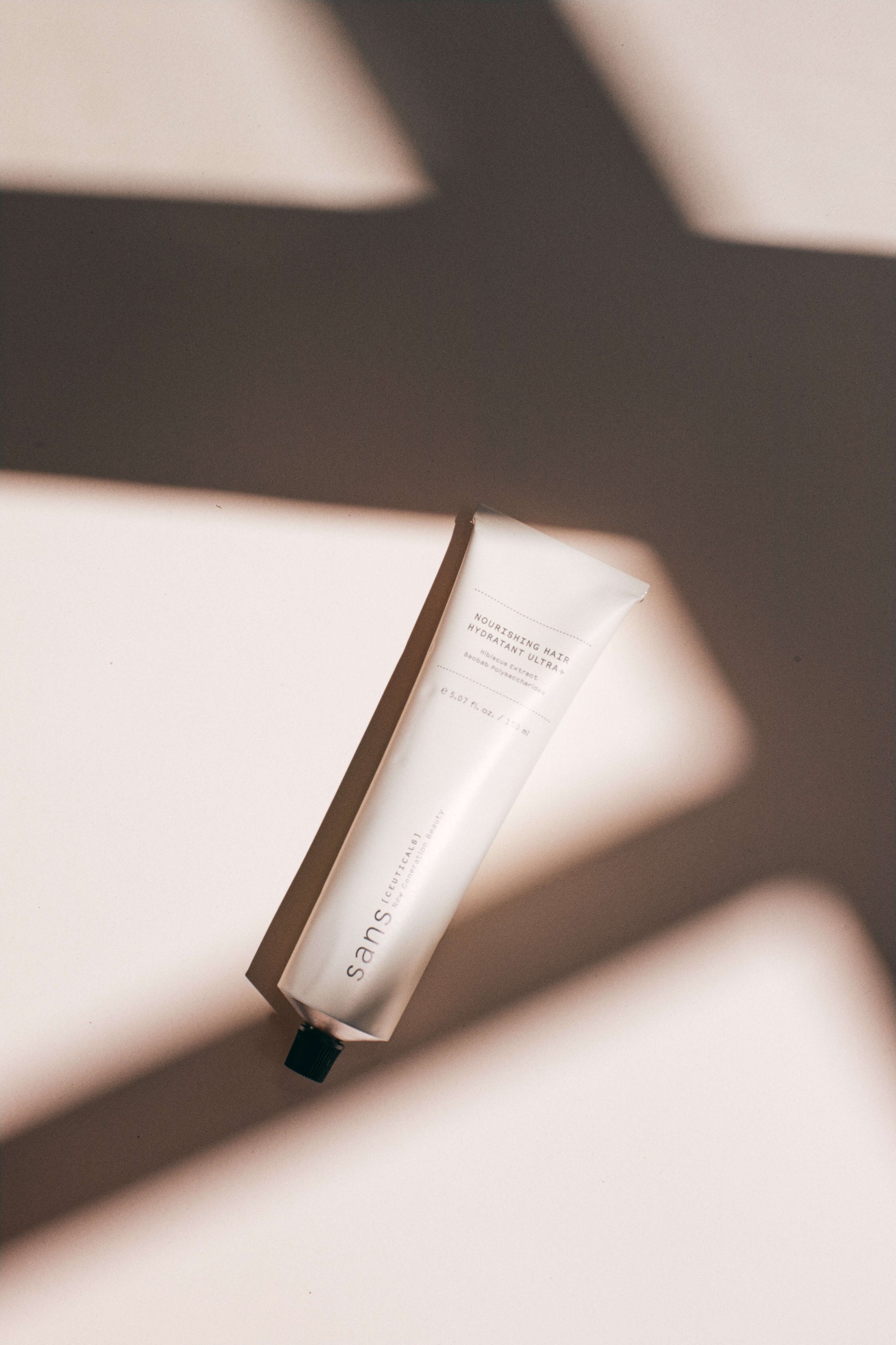 White tube of product on a neutral background