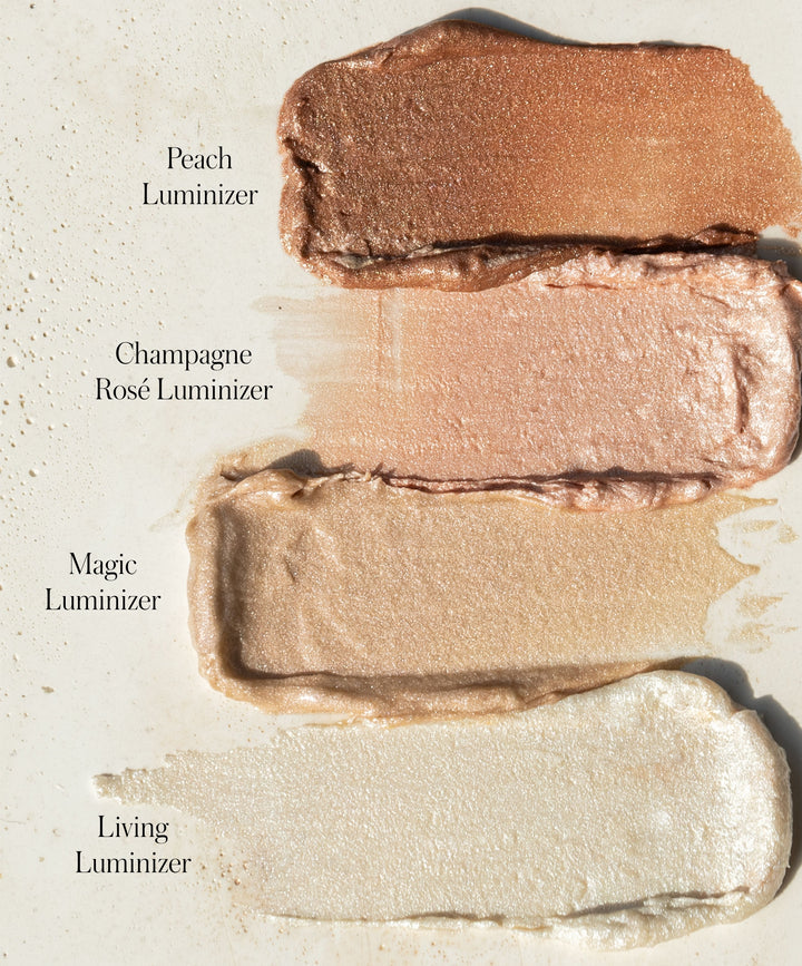 RMS Beauty Luminizer shade swatch comparison card showing textured swatches of Peach, Champagne Rosé, Magic, and Living Luminizer cream highlighters on cream background