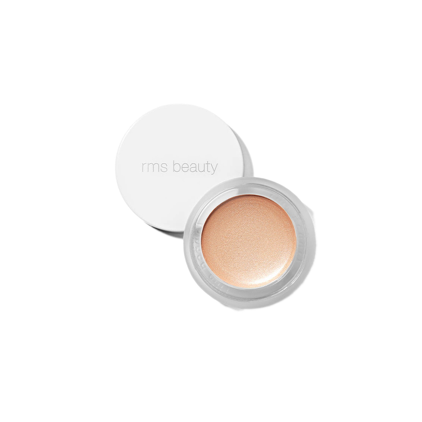 RMS Beauty Magic Luminizer in clear glass jar against plain white background showing warm champagne cream highlighter texture