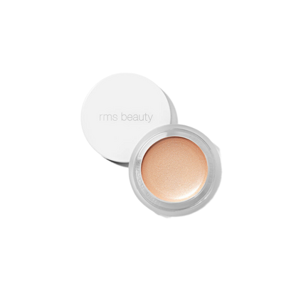 RMS Beauty Magic Luminizer in clear glass jar against plain white background showing warm champagne cream highlighter texture