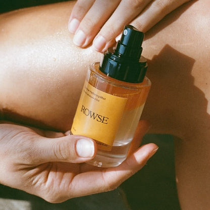 Hand holding a bottle of Rowse infront of their body