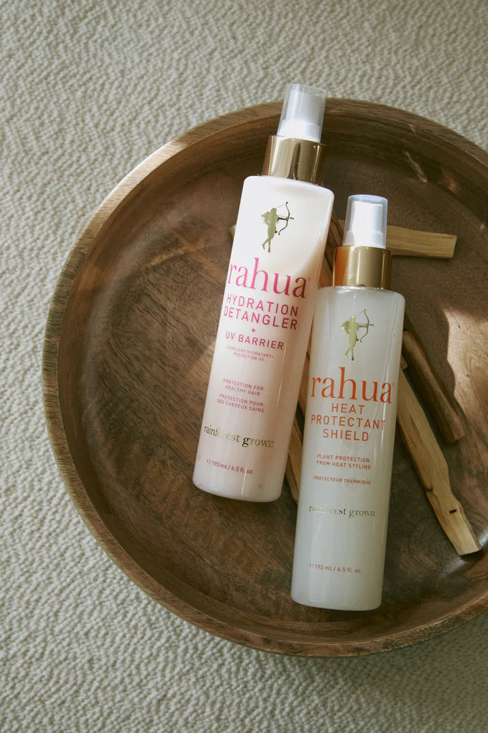 Two bottles of Rahua hair care products on a wooden tray.