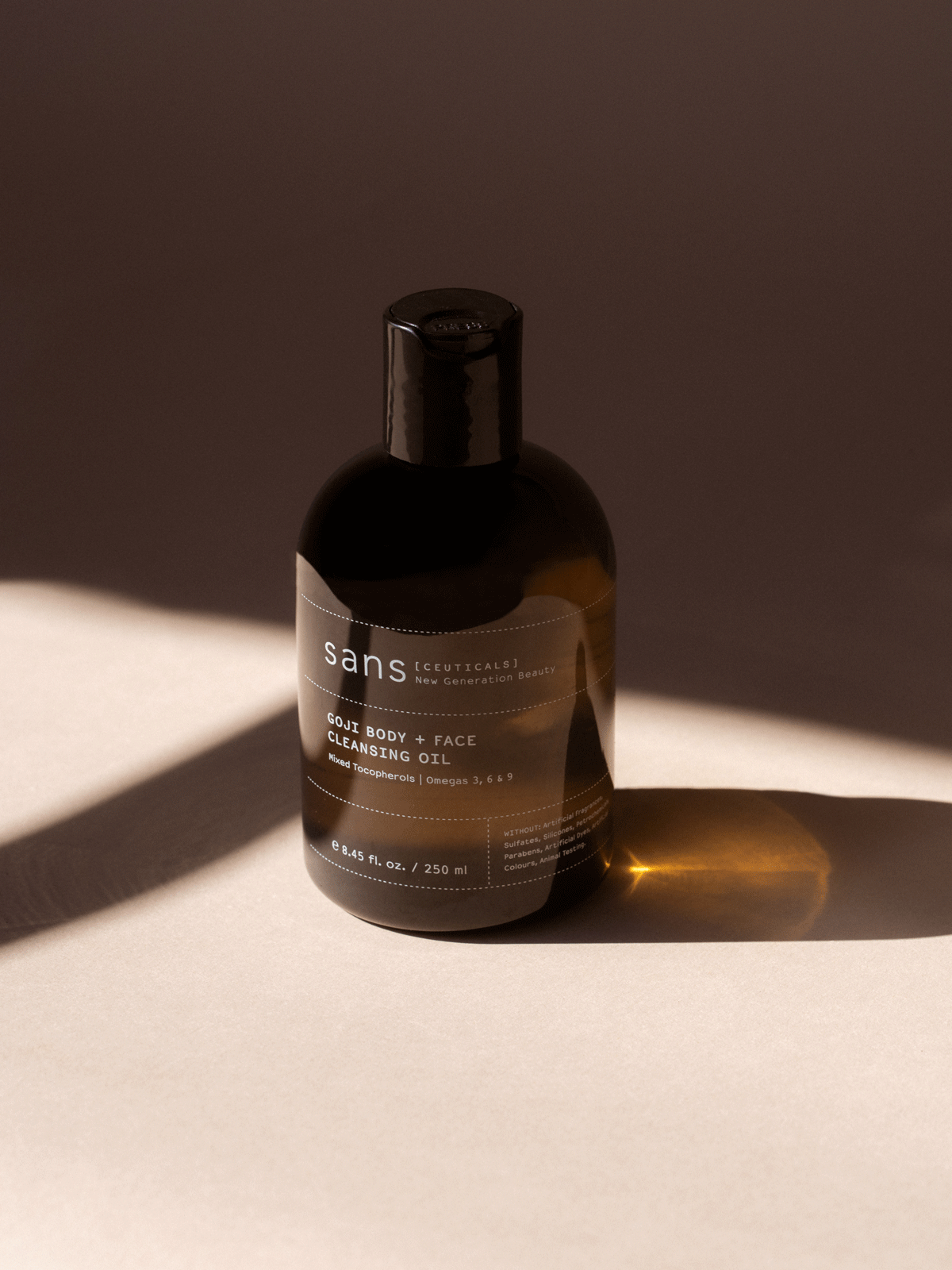 A dark-labeled bottle on a neutral background with shadows from the sun