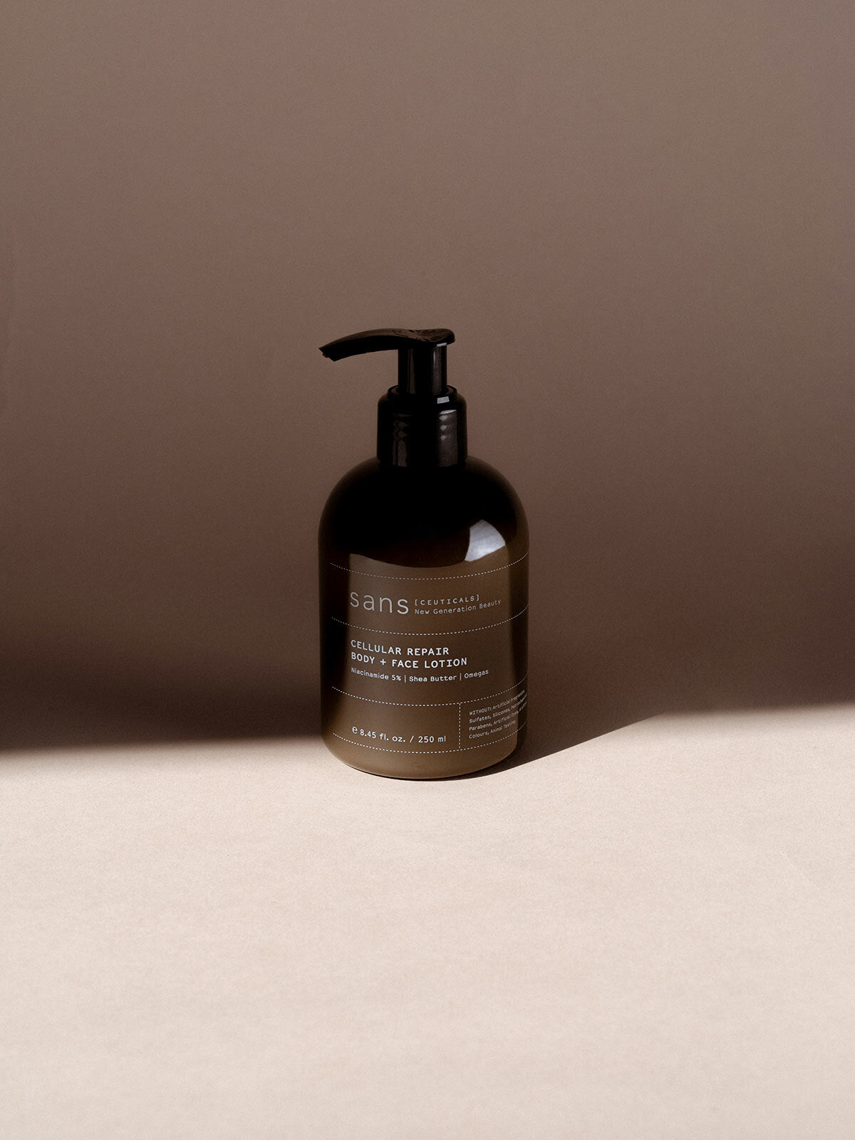 Bottle of body lotion with a label on a beige surface and brown background