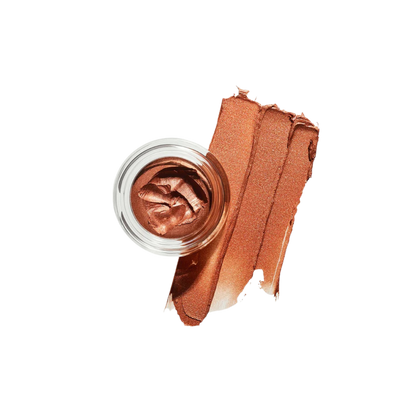 Bronze-colored makeup cream in a small jar with a swatch on a white background