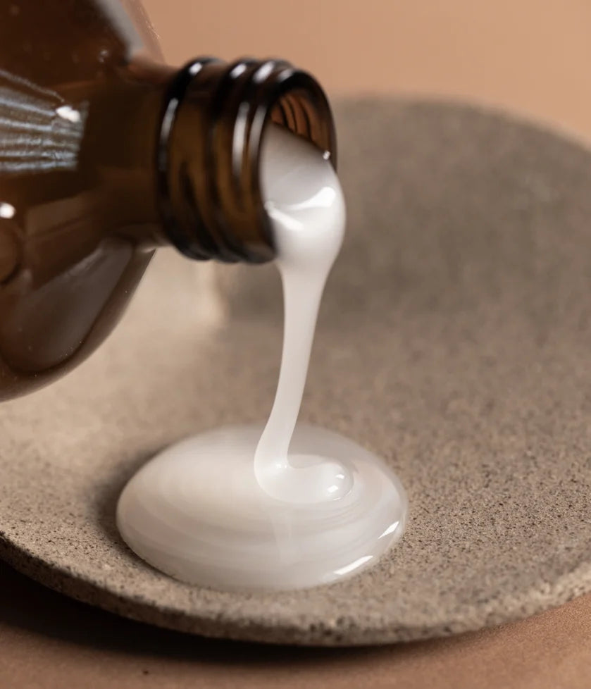 Smooth'n Glow Hair Bath shampoo 240mls by OWAY being poured onto natural dish