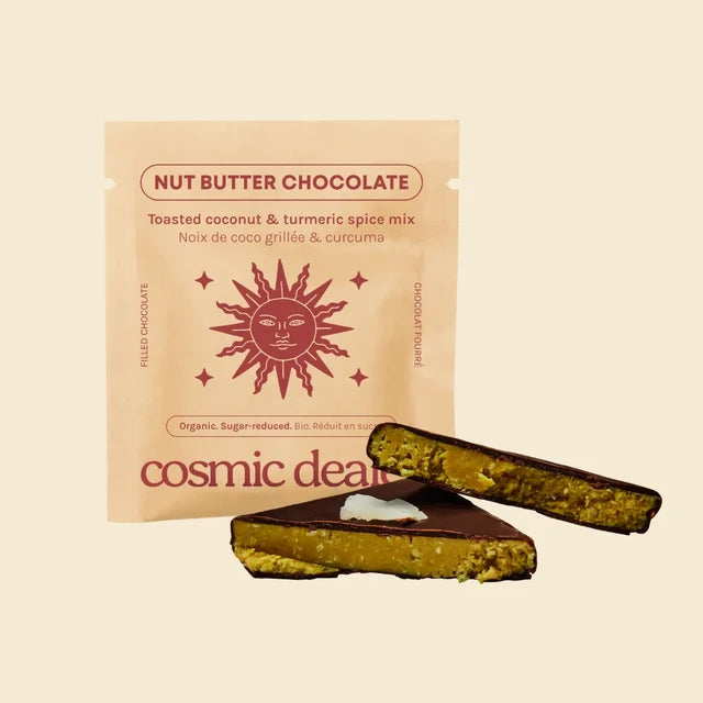 A single packet of Cosmic Dealer Nut Butter Chocolate coconut and tumeric spice mix, featuring a peach-coloured pouch with open cacao bar