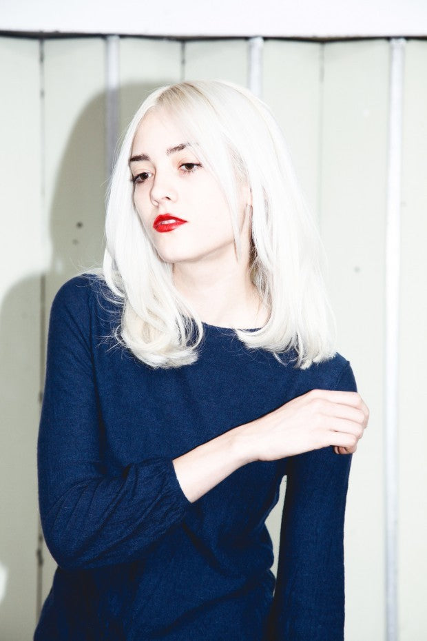Back view of model demonstrating seamless root blending and soft cool blonde tones from organic scalp lightening