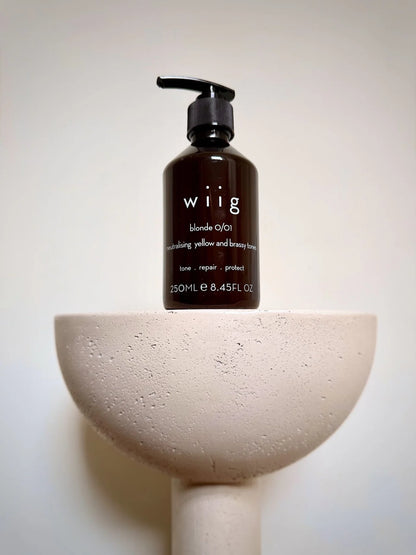 WIIG Blonde 0/01 Toning Treatment 250ml bottle on a pedestal, a salon-grade purple mask designed to neutralise yellow and brassy tones.