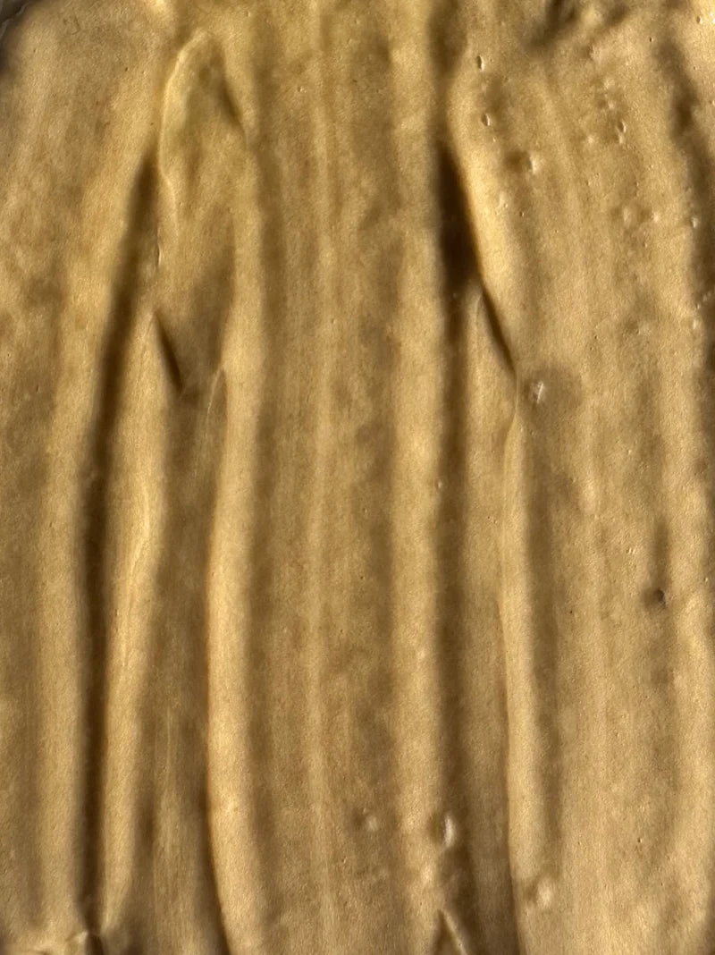 A close-up texture shot of a beige or light brown cream 